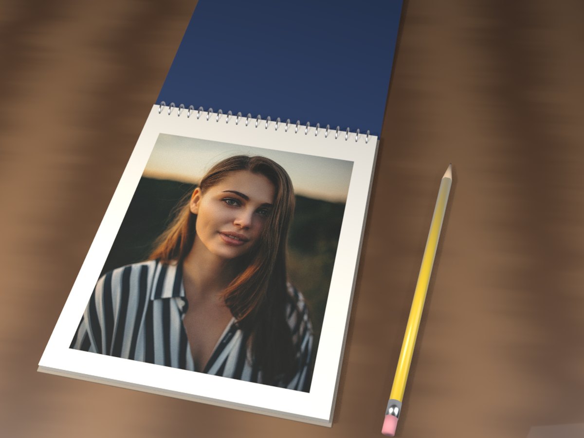 Sketch pad GIF: a spiral pad on a wooden desk, its cover flipped back to show a photo of a woman
